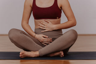 Eine schwangere Frau im 1.Trimester hält ihren Bauch