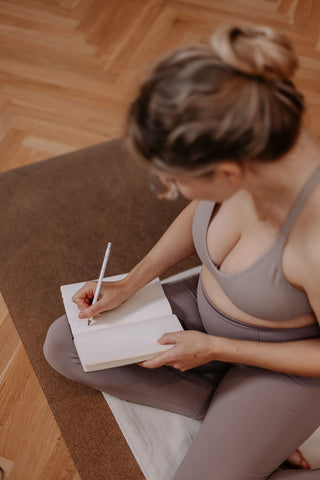 Eine Schwangere Frau macht einen Online Yoga Kurs und führt Tagebuch